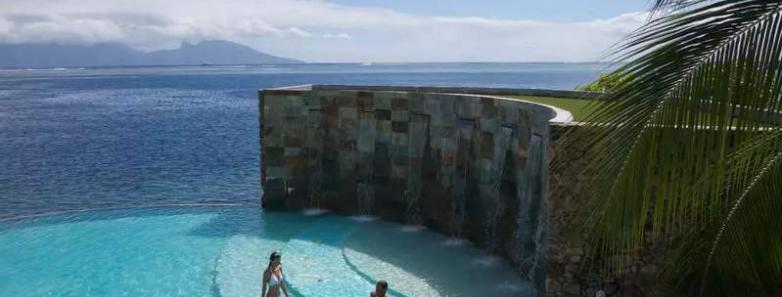 People enjoy the seaside infinity pool at Te Moana Tahiti Resort