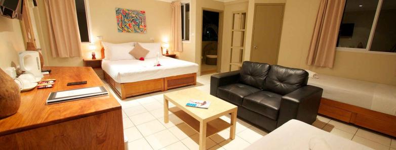 A large room with several beds and a couch at The Espiritu Vanuatu.